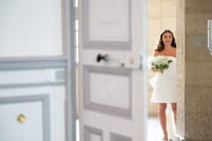 Organisation de mariage orchestré par Version Luxe Evenements leur wedding planner à uzes dans le gard : la mariée porte une robe courte avec des manches bouffantes , elle tient un bouquet de gypssophil blanc.